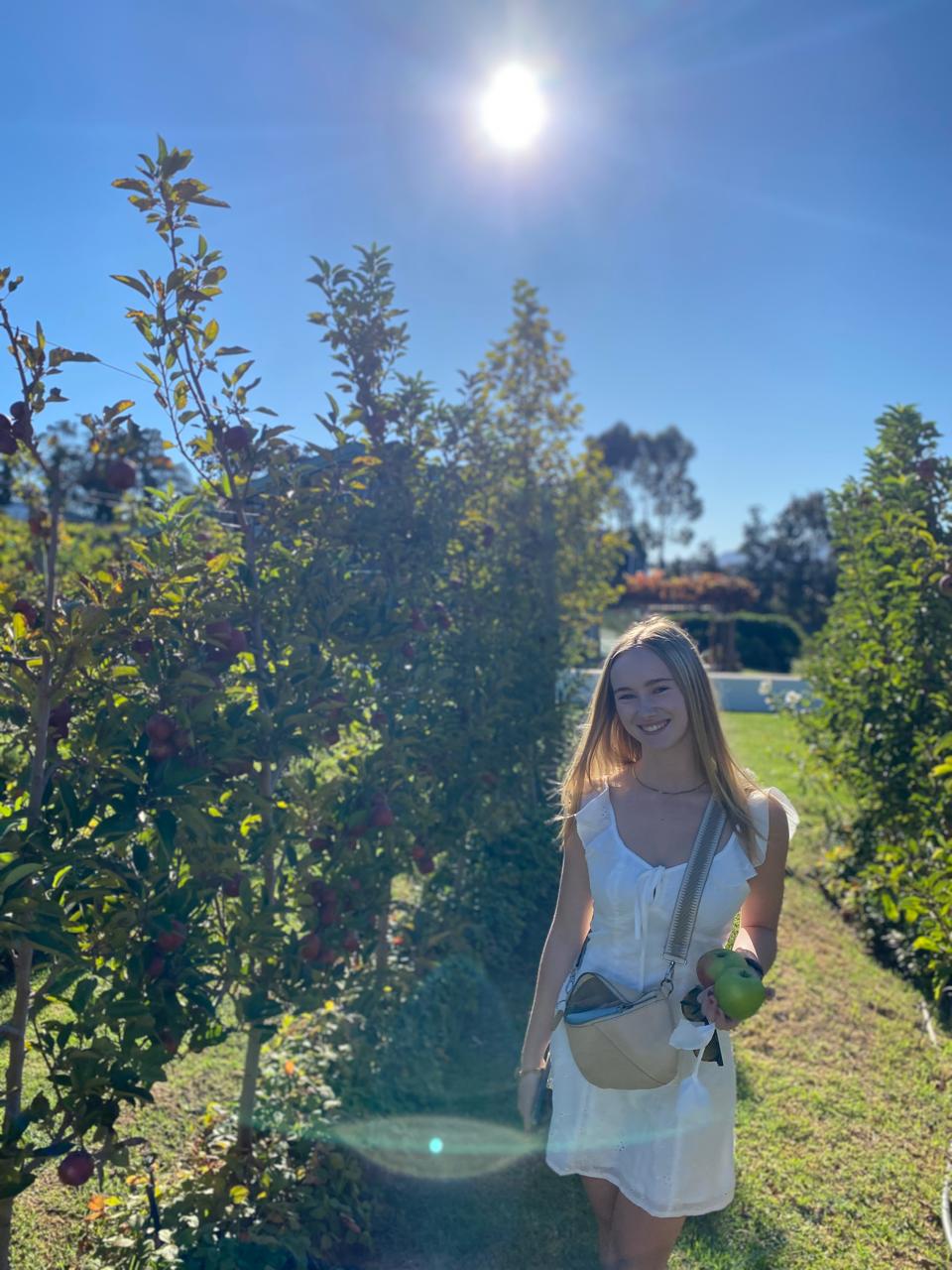 Gabriella in an apple orchard on a sunny day